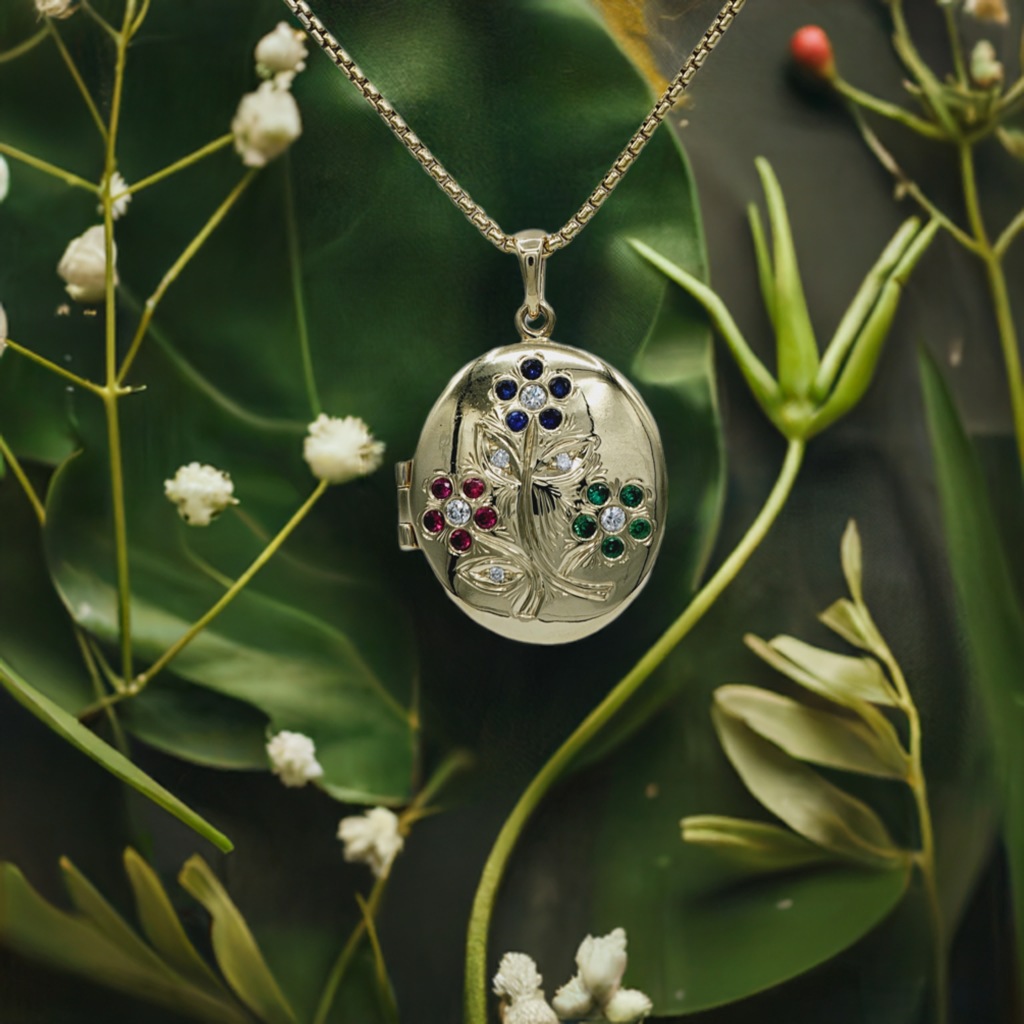 a 14K yellow gold locket with a gemstone floral motif made by Heileman & Company Jewelers