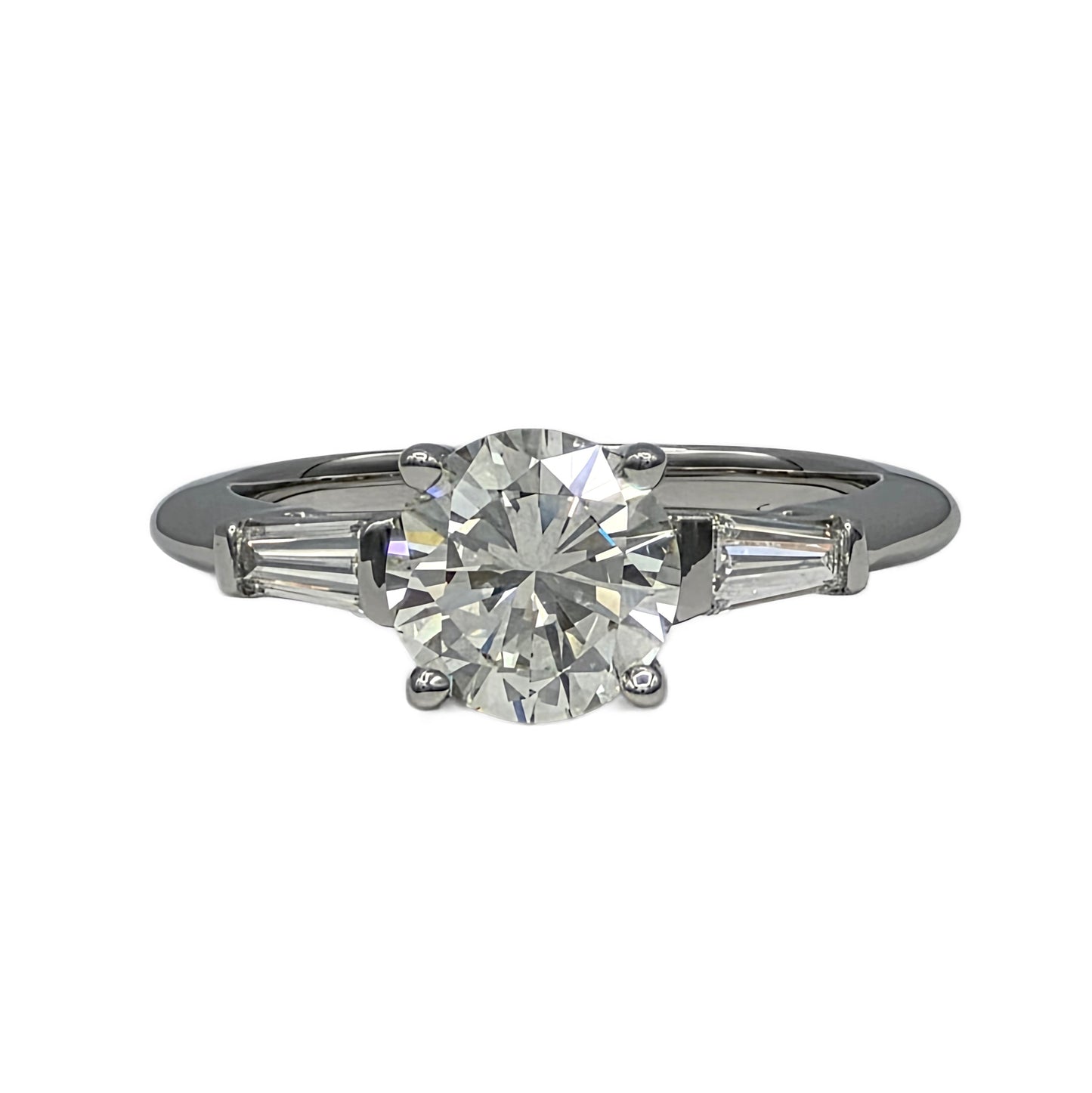 Diamond ring with a central diamond and two smaller diamonds on the sides on a white background