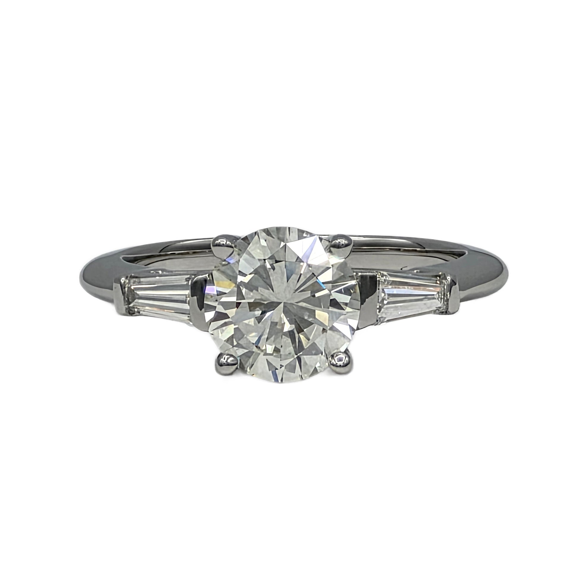 Diamond ring with a central diamond and two smaller diamonds on the sides on a white background