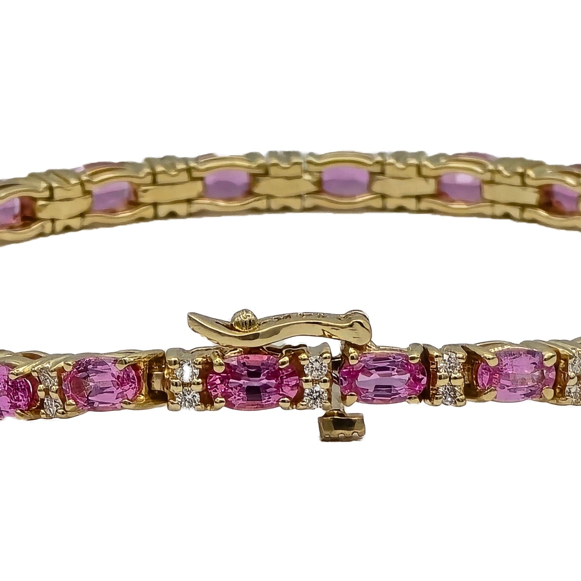 closeup of oval pink sapphire and diamond bracelet in 14K yellow gold